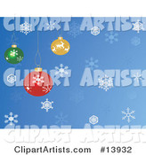 Red, Yellow and Green Christmas Baubles Hanging over a Blue Snowflake Background