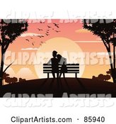 Silhouetted Couple Sitting in a Bench and Watching the Sun Set