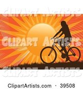 Silhouetted Woman Riding a Bicycle on a Hill Against an Orange Sunset
