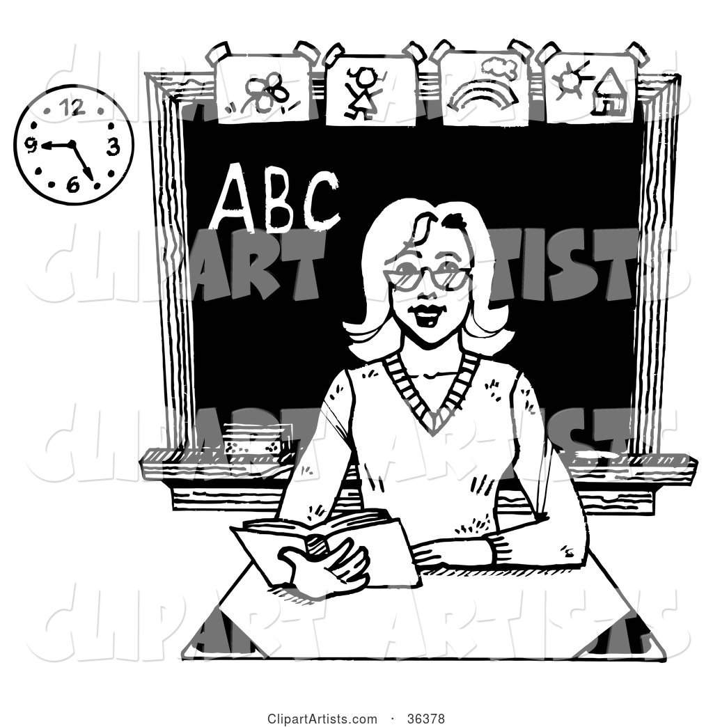 Friendly Female Teacher Reading a Book at Her Desk in a Class Room