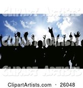 Silhouetted People Holding Their Hands in the Air Against a Sunburst in a Blue Sky