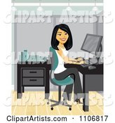 Happy Asian Businesswoman Working at a Desk in Her Office